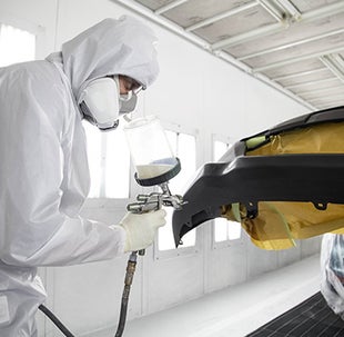 Collision Center Technician Painting a Vehicle | Toyota of Grand Rapids in Grand Rapids MI